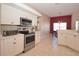 Bright kitchen with stainless steel appliances, white cabinets, and a view into the dining area with red accent wall at 41 Ormond Green Blvd, Ormond Beach, FL 32174