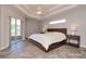 Comfortable main bedroom with wood accent wall, tray ceiling, and sliding glass doors to covered patio at 41 Ormond Green Blvd, Ormond Beach, FL 32174