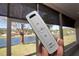 Close up of remote controlling window shade with lake view in background at 41 Ormond Green Blvd, Ormond Beach, FL 32174