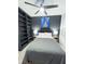 Comfortable bedroom featuring built-in shelving, modern ceiling fan, and neutral color palette at 4133 Gilford Cir, Ormond Beach, FL 32174