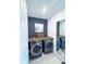 Well-equipped laundry room featuring a dark accent wall and modern washer and dryer units at 4133 Gilford Cir, Ormond Beach, FL 32174