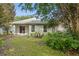 Backyard with covered patio surrounded by lush, mature landscaping at 417 Victoria Hills Dr, Deland, FL 32724