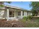 Rear view of the house, featuring a covered patio, slider door, and green foliage at 417 Victoria Hills Dr, Deland, FL 32724