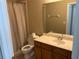 Bathroom featuring a toilet, sink with wooden vanity, large mirror, and shower with light beige curtain at 417 Victoria Hills Dr, Deland, FL 32724