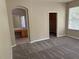Bedroom with gray carpet, beige walls, window with blinds and bathroom and closet entrances at 417 Victoria Hills Dr, Deland, FL 32724