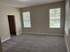 Bright bedroom featuring neutral walls, gray carpet, natural light from two windows, and a walk-in closet at 417 Victoria Hills Dr, Deland, FL 32724