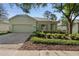 Charming single-story home featuring a two-car garage, brick driveway, and lush landscaping at 417 Victoria Hills Dr, Deland, FL 32724