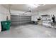 Spacious garage featuring large door, overhead storage, and workbench area at 417 Victoria Hills Dr, Deland, FL 32724