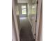 Hallway featuring gray carpet and view of bright bedroom with natural lighting and a window at 417 Victoria Hills Dr, Deland, FL 32724