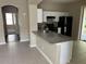 Open kitchen with a granite countertop island, white cabinets, and stainless steel appliances at 417 Victoria Hills Dr, Deland, FL 32724