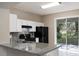 Well-lit kitchen featuring granite countertops, black appliances, and a sliding glass door at 417 Victoria Hills Dr, Deland, FL 32724