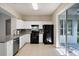 Bright kitchen featuring white cabinets, granite countertops, stainless steel dishwasher, and a black gas range at 417 Victoria Hills Dr, Deland, FL 32724