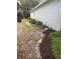 Narrow side yard with mulch, vegetation, and an external wall at 417 Victoria Hills Dr, Deland, FL 32724