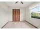 Cozy bedroom with neutral carpet, a large window, and a closet with folding doors at 441 E Kicklighter Rd, Lake Helen, FL 32744