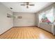 Clean living room featuring wood laminate flooring, ceiling fan, and a large window at 441 E Kicklighter Rd, Lake Helen, FL 32744