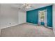 Inviting bedroom with neutral carpet, a closet, a window, and a striking accent wall at 486 Sycamore Springs St, Debary, FL 32713