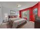 Cozy bedroom with red accent wall, large window, and comfortable furnishings at 486 Sycamore Springs St, Debary, FL 32713
