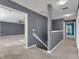 Second floor hallway with carpet and gray walls leading to a room with blue curtains at 486 Sycamore Springs St, Debary, FL 32713