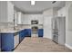 Well-equipped kitchen with stainless steel appliances, white cabinets and blue lowers at 486 Sycamore Springs St, Debary, FL 32713