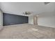 Open living room featuring neutral carpet, fan, and a striking accent wall at 486 Sycamore Springs St, Debary, FL 32713