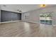 Bright living room with wood floors, ceiling fan, and sliding glass doors to the outdoor pool area at 486 Sycamore Springs St, Debary, FL 32713