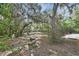 Scenic backyard with foliage, with benches nestled under a canopy of trees, inviting relaxation and contemplation at 5265 Myakka Rd, De Leon Springs, FL 32130