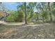 The spacious backyard features lush trees and a storage shed near the house, offering lots of space at 5265 Myakka Rd, De Leon Springs, FL 32130