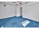 A well-lit bedroom with unique blue carpet, a ceiling fan, closet, and white door offering ample storage at 5265 Myakka Rd, De Leon Springs, FL 32130