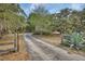 Long paved driveway leading to a private estate with mature trees and landscaping at 5265 Myakka Rd, De Leon Springs, FL 32130