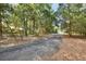 Long, paved driveway surrounded by natural woodland creates a private entry at 5265 Myakka Rd, De Leon Springs, FL 32130