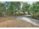 Long driveway leading to a sprawling brick home surrounded by lush greenery and mature trees at 5265 Myakka Rd, De Leon Springs, FL 32130