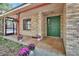 Charming covered front porch featuring potted plants, brick accents, and a green front door at 5265 Myakka Rd, De Leon Springs, FL 32130