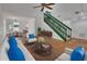 Bright living room featuring tile floors, a staircase with green railing, and views into dining area at 5265 Myakka Rd, De Leon Springs, FL 32130