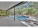 Screened in pool with a waterfall feature, providing a private oasis for relaxation and enjoyment at 5265 Myakka Rd, De Leon Springs, FL 32130