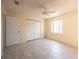 Bright bedroom featuring a ceiling fan, neutral tile floor, and closet at 5519 Silent Brook Dr, Orlando, FL 32821