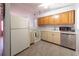 Functional kitchen features white appliances, light wood cabinets, and tile floors at 5519 Silent Brook Dr, Orlando, FL 32821