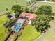 A breathtaking aerial view of a property with a screened pool, lush landscaping, and surrounded by green pastures at 5549 Aragon Ave, De Leon Springs, FL 32130