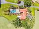 Stunning aerial view of estate home with screened pool, lush landscaping and surrounded by green pastures and mature trees at 5549 Aragon Ave, De Leon Springs, FL 32130