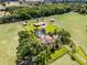 Aerial view of a sprawling estate featuring a home with a screened pool, barn, and lush landscaping at 5549 Aragon Ave, De Leon Springs, FL 32130