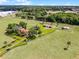 Areal view of estate, featuring main house, secondary structure, driveway, pasture and extensive fencing at 5549 Aragon Ave, De Leon Springs, FL 32130