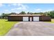 A long metal barn featuring 2 garage doors with a large asphalt parking area at 5549 Aragon Ave, De Leon Springs, FL 32130