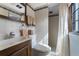 Cozy bathroom with a wood-trimmed sink, toilet, shower, and tile accents around the room at 5549 Aragon Ave, De Leon Springs, FL 32130