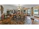 Spacious dining area featuring hardwood floors, decorative rug, chandelier, and ample natural light for an elegant dining experience at 5549 Aragon Ave, De Leon Springs, FL 32130