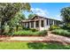 A lovely property framed by a brick walkway and lush landscaping, leading to a charming facade with inviting porch at 5549 Aragon Ave, De Leon Springs, FL 32130