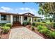 This home features a brick walkway and lush landscaping, creating an inviting entrance to the property at 5549 Aragon Ave, De Leon Springs, FL 32130