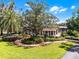 Charming home surrounded by manicured landscaping, brick walkways, mature trees, and lush green lawn for a welcoming appeal at 5549 Aragon Ave, De Leon Springs, FL 32130