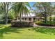 This home features a large, lush front yard with mature trees and a brick walkway, creating an inviting and serene setting at 5549 Aragon Ave, De Leon Springs, FL 32130