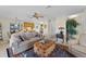 Comfortable living room with neutral walls, a ceiling fan, large sofa and trunk-style coffee table at 5549 Aragon Ave, De Leon Springs, FL 32130