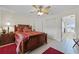 This main bedroom features tan tile flooring, a ceiling fan, and a doorway to the on-suite bathroom at 5549 Aragon Ave, De Leon Springs, FL 32130