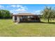 Enclosed sunroom with tiled roof and multiple windows overlooking the grassy yard and perimeter fencing at 5549 Aragon Ave, De Leon Springs, FL 32130